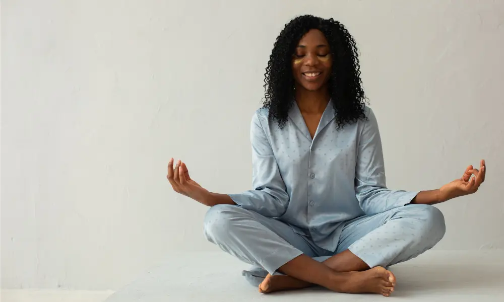 A woman sits cross-legged while meditating