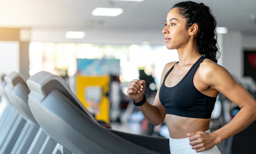 a woman runs on a treadmill at the gym