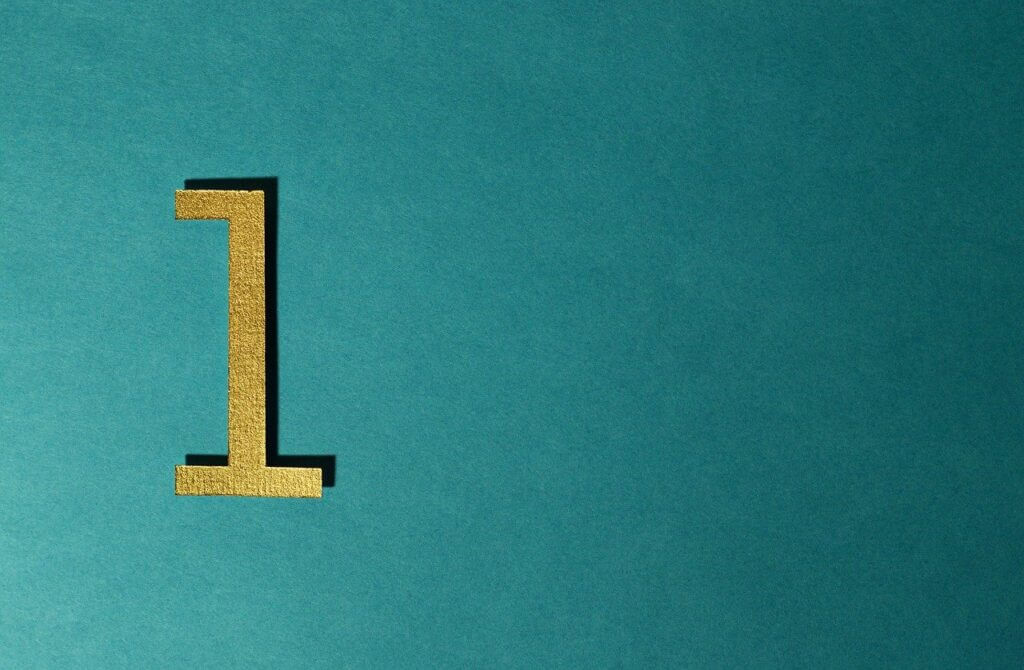 Teal background with a gold glitter number 1 cut out displayed on the left side of the image