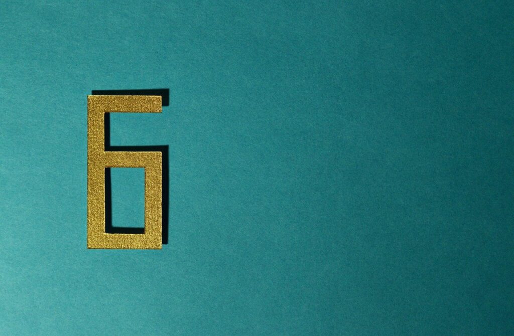 Teal background with a gold glitter number 6 cut out displayed on the left side of the image