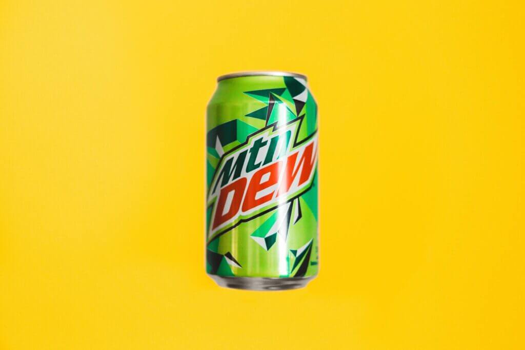 yellow background with Mountain Dew soda can floating in the center of the image