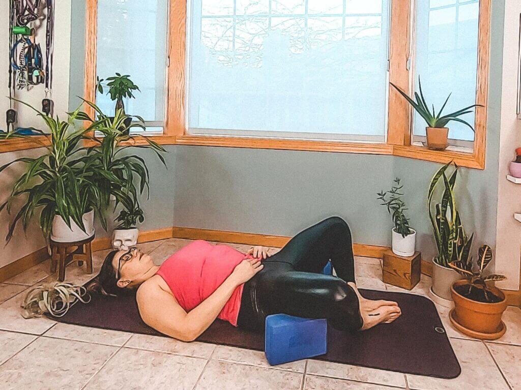 Lay flat on back knees fan out right and left open pelvis and hips each knee rests on a yoga block