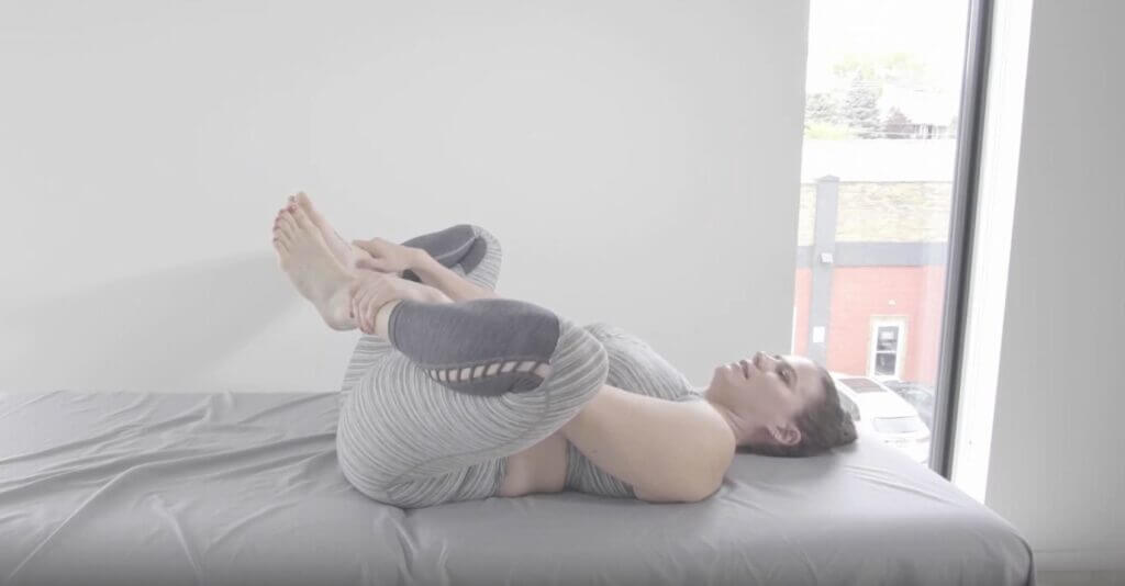 Lay flat on back hands grabbing ankles and helped by hands pull feet up to pelvis bending hips knees