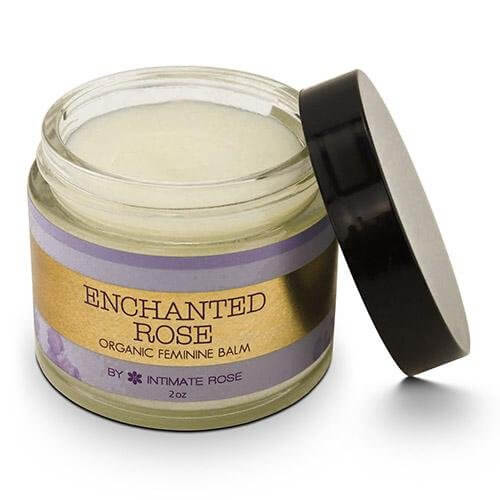 Round glass container black lid is open showing balm label read Enchanted Rose Organic Feminine Balm