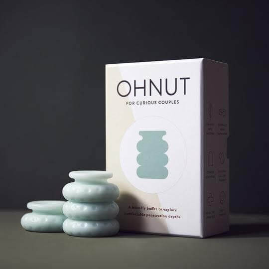 OHNUT box with 4 rings sitting in front of it 3 rings stacked and connected to each other 1 is aside