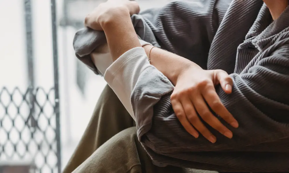 close up of an individual sitting with their arms crossed