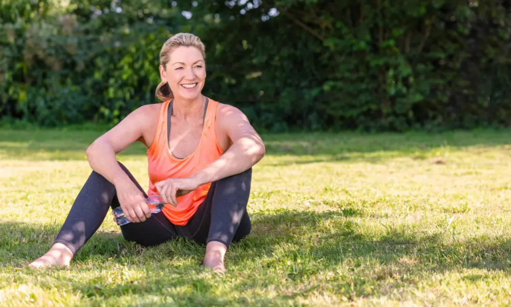 exercise-during-menopause A woman sits outside in athletic attire