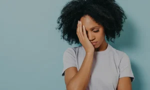 Woman holding her face with one hand with a sad expression