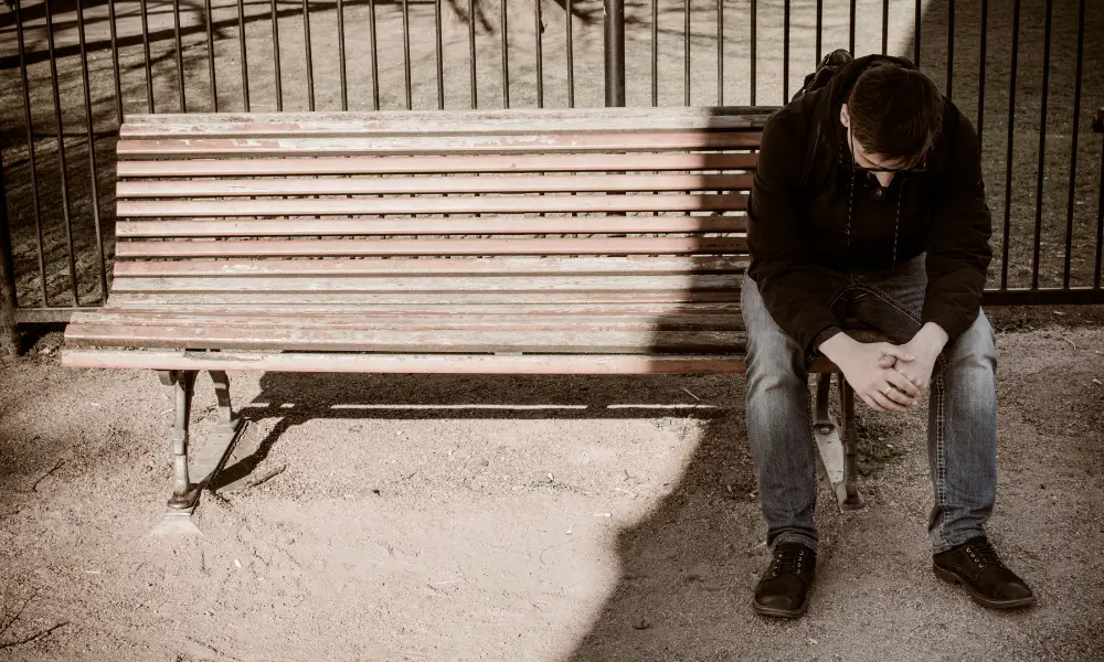 Man sitting on a bench looking dejected