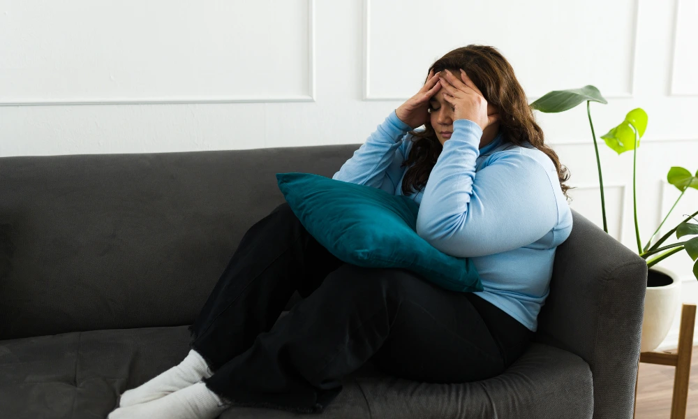 Woman sitting on a couch looking frustrated