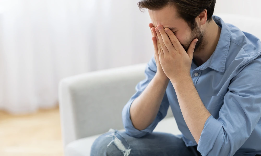 Man holding his face with both hands in frustration