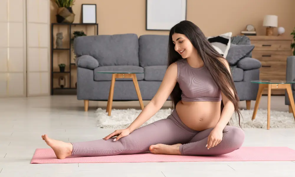 A pregnant individual engages in gentle yoga