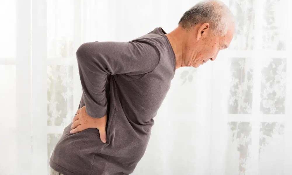 age-related-SI-joint-pain Older individual struggling with back pain
