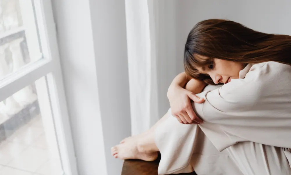 woman-hugging-knees-sadly A woman hugs her knees sadly