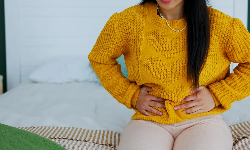 Woman using both hands to hold her pelvis