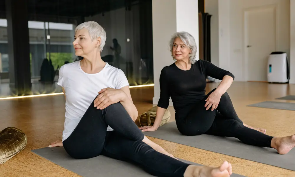 women-doing-yoga Two women doing yoga inside